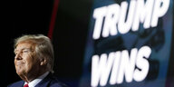 Donald Trujmp vor einer Leuchtschrift "Trump Wins"