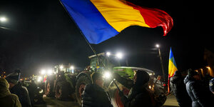 Eine rumänische Flagge wird über einem Traktor geschwenkt