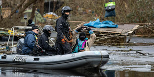 Polizeischlauchboot fährt durch einen Tümpel mit Besetzer