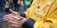 Auf der gelben Jacke einer Frau hängen Anti-Atom-Buttons
