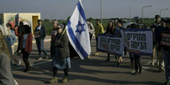 Eine Gruppe von Menschen protestiert mit Schildern und israelischer Flagge