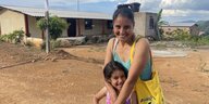 Yaquelin Yajure steht mit ihrer fünfjährigen Tochter vor dem neugebauten Haus in Kolumbien.