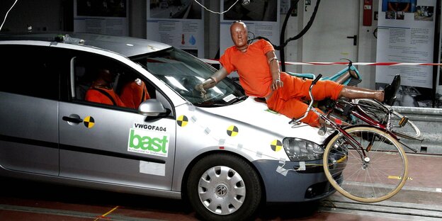 Ein Crash-Test-Dummy auf der Motorhaube eines Fahrzeuges