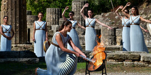 Frauen in antiken Gewändern bei der Entzündung des olympischen Feuers.
