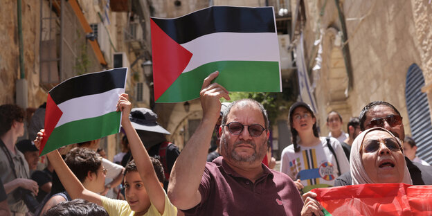 Viele Menschen demonstrieren mit Pro-Palästina-Schildern