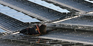 Ein Mann arbeitet an einer Dachsolaranlage