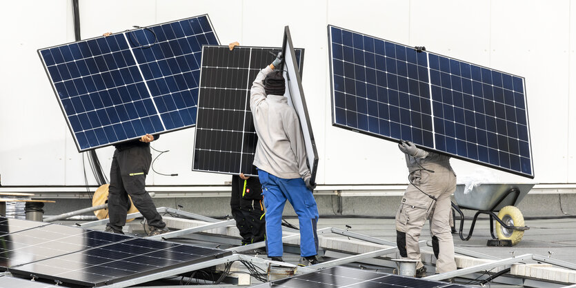 Menschen tragen Solarmodule