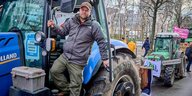 Ein Bauer steigt fürs Foto aus seinem Traktor aus: Johann Gerdes auf der "Wir haben es satt"-Demonstration in Berlin am 20. Januar 2024