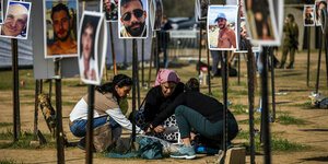 Trauernde zwischen Fotos ihrer getöteten Angehörigen