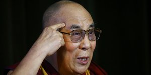 Der Dalai Lama fasst sich an den Kopf