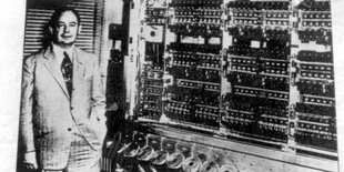 John von Neumann steht neben einem historischen EDVAC-Rechner in Princeton