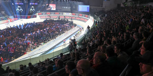 Blick von den vollen Zuschauerrängen auf die Holzbahn und die Radprofis in der Bremer Arena