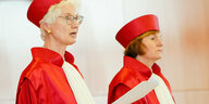 Zwei Richterinnen der Bundesverfassungsgerichts in roten Roben und mit roten Hauben, weißen Schärpen