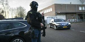 Maskierte und bewaffnete Polizisten bewachen einen Transport mit einigen Der Verdächtigen, die vor dem HochsicherheitsgebäuDe Des Gerichts in Amsterdam eintreffen