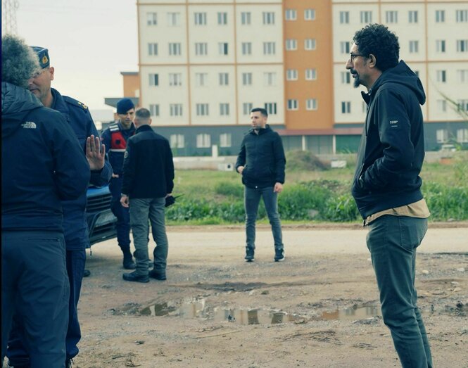 Ein beobachtet, wie Polizisten mit einem anderen Mann reden.