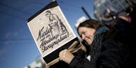 Eine Frau hält ein Schild mit einer Zeichnung von Käthe Kollwitz, die eine schwangere Frau mit Baby im Arm zeigt und der Forderung: Nieder mit dem Abtreibungs-Paragraphen