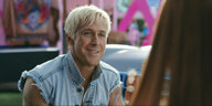 Foto von Ryan Gosling mit Jeansjacke als Ken, der verschmitzt lächelt