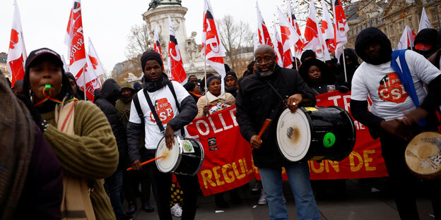 Protest gegen das neue Einwanderungsgesetzt in Frankreich - Menschen mit Trommeln und Pfeifen und Flaggen der CSP