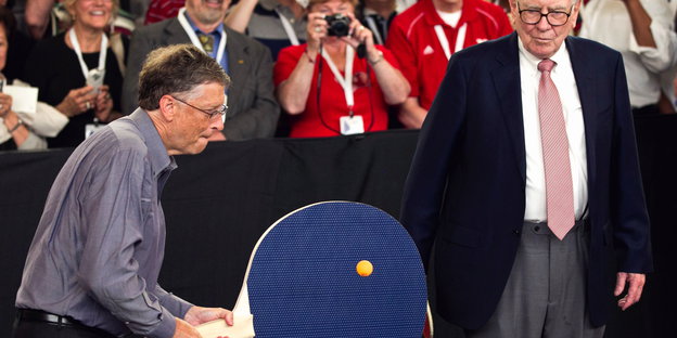 Bill Gates (l) und Warren Buffett (r) spielen Tischtennis
