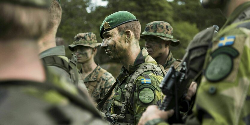 Schwedische Soldaten in Camouflage-Uniform und bemalten Gesichtern