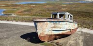 Ein Boot liegt am betonierten Rand einer fast ausgetrockneten Seenlandschaft