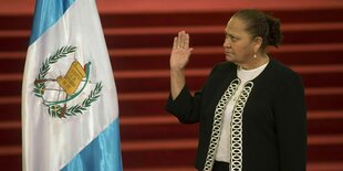 Maria Consuelo Porras Argueta, Guatemalas Generalstaatsanwältin, hebt während ihrer Vereidigung 2018 im die Hand - neben ihr die Flagge Guatemalas