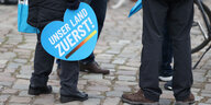 Menschen halten Transparente mit der Aufschrift "Unser Land zuerst" bei einer Wahlkampfveranstaltung der AfD vor dem Schloss Charlottenburg.