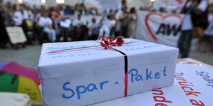 Demonstranten mit einem symbolischen "Spar-Paket"