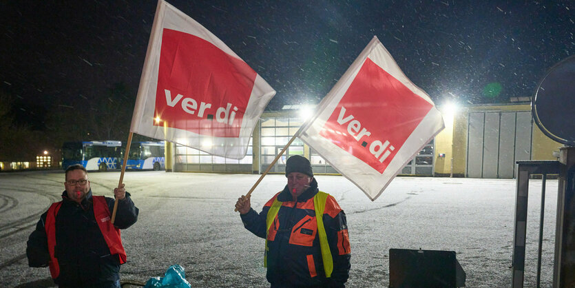 Streikposten mit Fahnen.