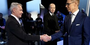 Die finnischen Präsidentschaftskandidaten Haavisto und Stubb reichen sich die Hände.