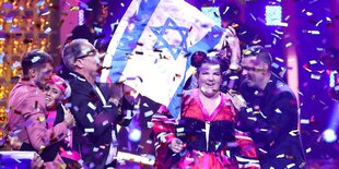 Die Sängerin Netta am Abend ihres Seges beim ESC - sie lacht, ihre Anhänger feiern sie, Konfetti fliegt und eine iraelische Flagge wird hochgehalten