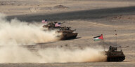 Panzer fahren durch eine Wüste.