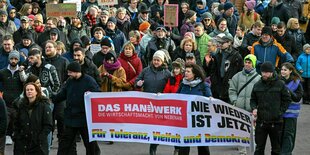 Teilnehmer der Demonstration «Nie wieder ist jetzt!» gehen durch Frankfurt/Oder.Sie tragen ein großes Banner: DasHandwerk die Wirtschaftsmacht von nebenan -Nie wieder ist jetzt -fürToleranz, Vielfalt und Demokratie