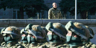 Ein Mann in Militäruniform schaut sich eine Militärparade an.