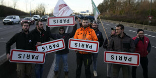 Protest auf einer Straße mit Schildern.