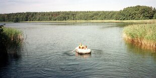 Kinder in einem Schlauchboot auf einem See.