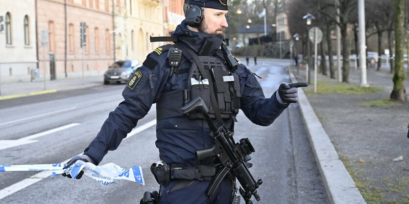 Ein Polizist steht auf einer Straße.