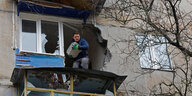 Ein mann steht auf dem zerstörten Balkon eines Wohnhauses