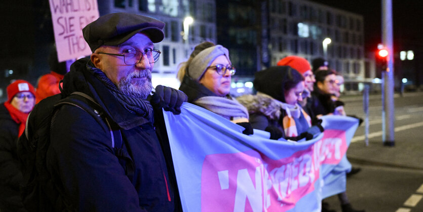 Mehrere Personen mit Transparent bei einer Demonstration.