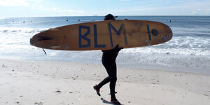 Mit der Aufschrift "BLM" (für "Black Lives Matter") gedenkt ein Surfer in New York, USA, der Opfer von Polizeigewalt