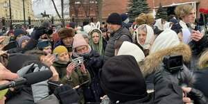 Mehrere Menschein in einer Menge vor den Mauern des Kreml