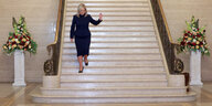 Michelle O'Neill schreitet auf eine riesigen Treppe herab. Sie trägt ein blaues Kleid