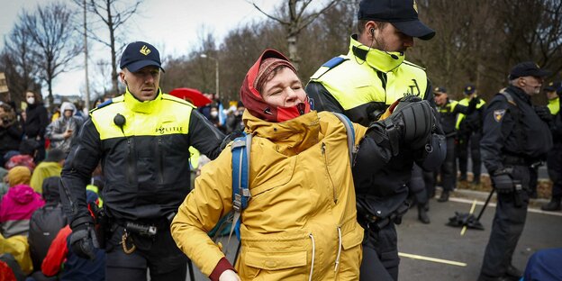 Klimaaktivisten von Extinction Rebellion werden während einer Blockade auf der Utrechtsebaan in Den Haag von Polizisten davon getragen