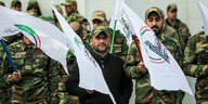 Mitglieder der irakischen Volksmobilisierungskräfte bei der Beerdigung von 16 Mitgliedern, die bei US-Luftangriffen getötet wurden
