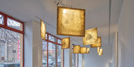 Blick in die Galerie Nagel Draxler mit Arbeiten von Zhao Gang. Unter der Decke hängen quadratische Malereien auf mit Seide bespannten Keilrahmen. Licht scheint von hinten durch die Seide. Es sind Tierumrisse zu erkennen.