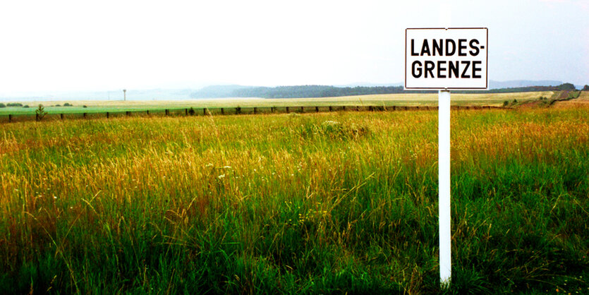 Schild mit Aufschrift Landesgrenze