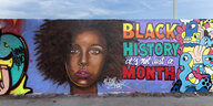 Graffiti an einer Mauer mit dem Gesicht einer Schwarzen Frau und dem Hinweis: Black History it's not just a month.