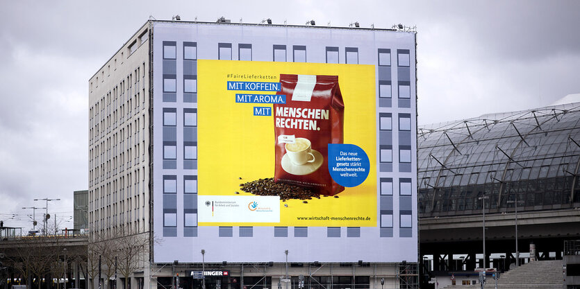 An einem Hochhaus ist ein großes Reklamebanner angebracht.