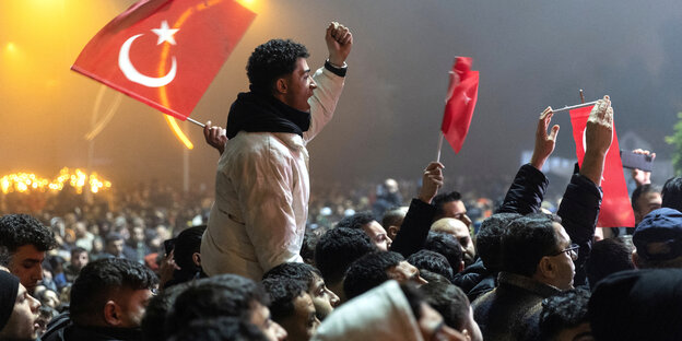 Menschen mit türkischen Flaggen recken empört die Fäuste