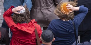 Zwei Frauen tragen Kippas, die sie festhalten müssen, weil ein starker Wind weht